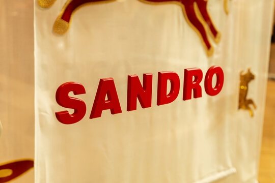 Singapore - January 27, 2026: Sandro store sign shows the brand name in bold red letters. The image captures the store's interior view in Singapore during daytime. Shoppers can be seen around