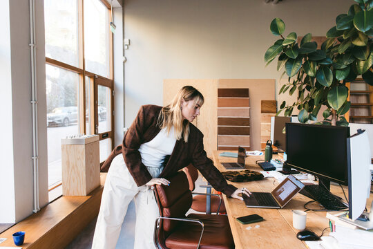 Female design professional using laptop while working in architectural office