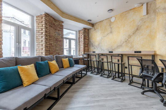 Modern hostel common area with sofa and coworking workspace