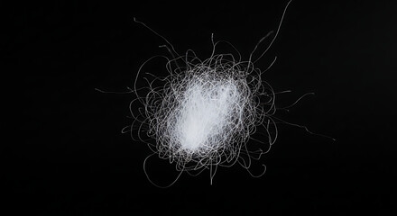 Naklejka premium Close-up of ethereal white downy fibers showcasing intricate tangle against a dark backdrop, highlighting texture and detail