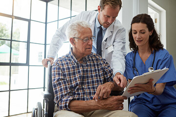 Obraz premium Doctor, nurse and old man in wheelchair with clipboard for healing or medical consulting. Conversation, paperwork and recovery of senior person with disability in hospital for rehabilitation advice