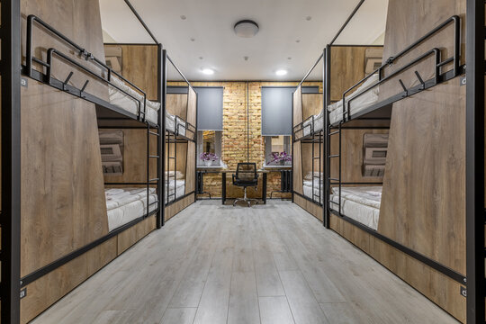 Symmetrical loft hostel dormitory with bunk beds and night city view