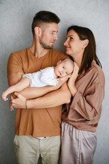 Fototapeta premium Parents Looking At Each Other While Holding Baby