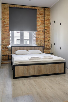 Modern loft-style hostel room with a double bed and exposed brick wall