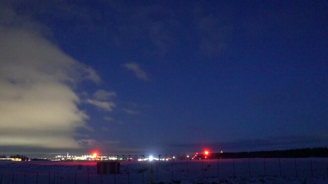 Stockholm, Sweden A plane takes off at night in winter on a runway at Arlanda Airport.