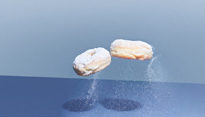 Powdered Donuts Suspended Over Reflective Blue Surface