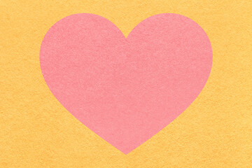 Obraz premium Pink heart on light yellow paper texture background with copy space for Valentines Day banner, template or greeting card