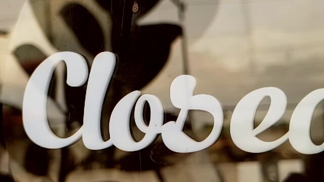 The word Closed in a stylish font on a glass door 