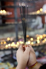 praying hands with incense sticks