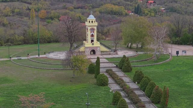 A powerful drone perspective of the Cegar Monument near Nis, Serbia, honoring the 1809 battle. Capturing the stone tower and the surrounding battlefield landscape at sunset.