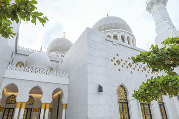 Low Angle View Of White Marble Mosque Exterior With Domes And Golden Window