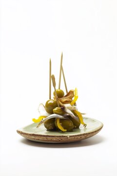 Pincho de aceitunas boquerones y pimientos en plato, Aperitivo espa&ntilde;ol gourmet aceitunas y boquerones, Fondo blanco para publicidad de tapas espa&ntilde;olas pincho gilda