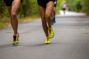 Legs two runners running road in autumn park