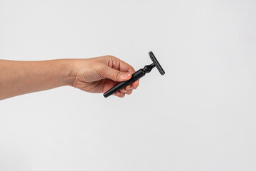 A fake black razor in hand against on white background.