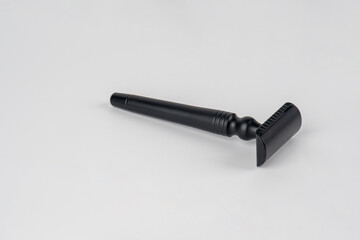 A fake black razor in hand against on white background.