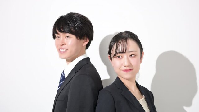 背中合わせで立つ若いビジネスマンの大学生のような男女の大学生イメージ　新卒採用や就職など信頼感を伝える企業採用イメージの動画