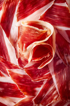 Lonchas de jam&oacute;n ib&eacute;rico apiladas vista superior, Art&iacute;culo sobre la tradici&oacute;n del jam&oacute;n ib&eacute;rico en Espa&ntilde;a, Fondo de textura jam&oacute;n ib&eacute;rico con espacio para texto