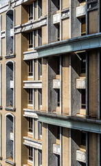 Fototapeta premium Modern building facade with rhythmic window design and dramatic sunlight and shadows 