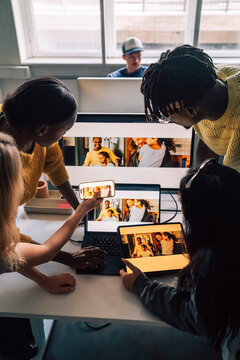 High angle view of creative professionals comparing software design preview on different technologies while working in t
