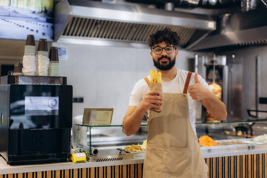 Arab chef holding shawarma giving thumbs up