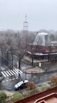 Nieve en iglesia con cielo nublado en calle de ciudad nevada con copos y viento
