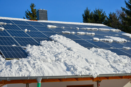 Neue Solaranlage, Photovoltaikanlage, auf dem Ziegeldach eines Einfamilien-Neubauhauses im Winter mit Schneeauflage