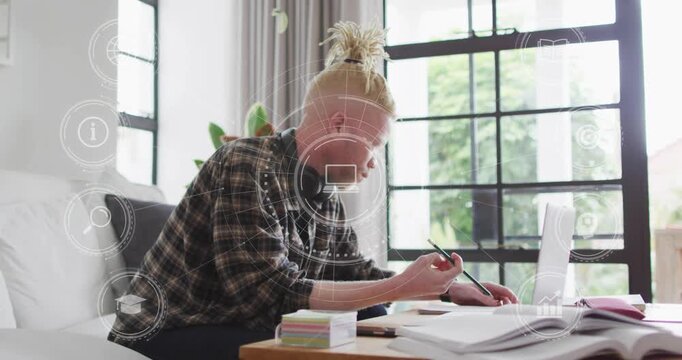 Man pressing laptop trackpad and writing notes, starting floating tech graphics for data capture
