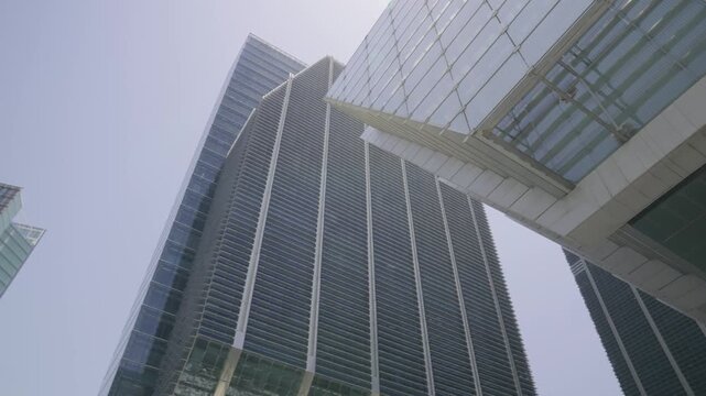 Cinematic tilt camera movement revealing the height and design of ADGM towers in Abu Dhabi, filmed in daylight using a mirrorless camera.