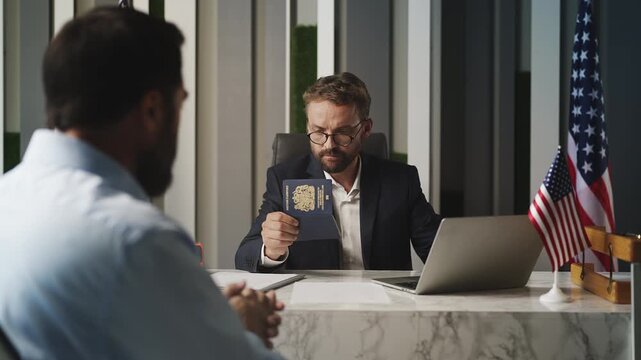 Male U.S. embassy worker approving visa and handing U.K. passport to applicant