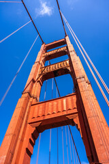 Fototapeta premium Golden Gate Bridge pedestrian walkway with red cables and blue sky