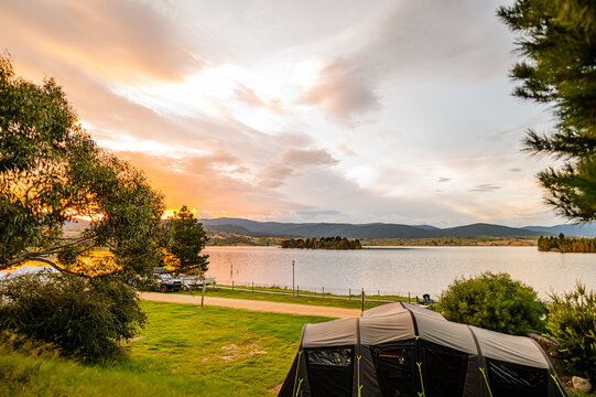 a camping ground next to a lake during sunset