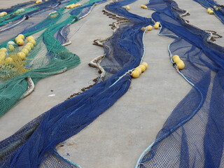 Zum Trocknen ausgelegte Fischernetze auf einem Hafengel&auml;nde