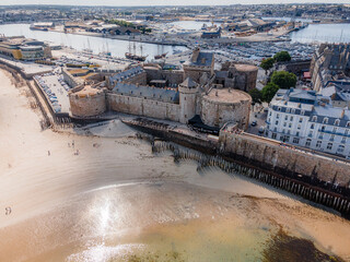 Aerial view of the Castle of Saint-Malo in Brittany, France, showing its fortified walls, towers, and ramparts surrounded by the historic walled city and coastal landscape.

