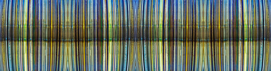 a close-up abstract photograph of the edges of a stack of CDs or DVDs with glue drops