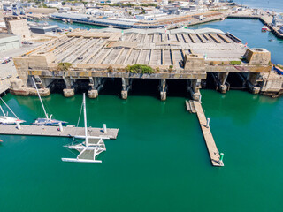 Aerial view of the massive submarine docks at Lorient, revealing reinforced concrete bunkers, harbor basins, and the historic naval infrastructure along the coast of Brittany, France.

