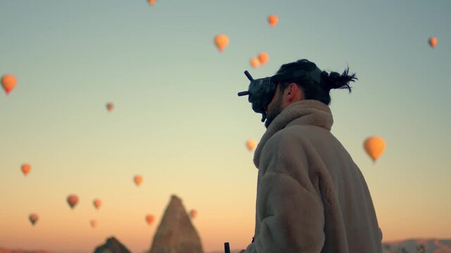 Man wearing virtual reality or FPV goggles while controlling a drone outdoors. Modern technology and innovation concept showing immersive drone piloting, aerial control, and future tech lifestyle.