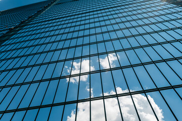 Selective focus on high green metal fence with rectangular cells against cloudy sky