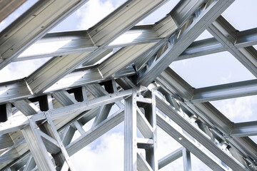 Obraz premium New home construction framing. Metal stud framing system with rust resistant coating in a drywall assembly. Structure of steel for building construction. Metal house frame.