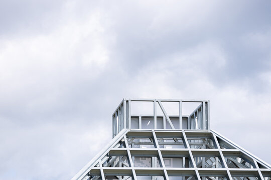 Close-up of a modern galvanized light steel frame LSF construction. Architectural details of roof trusses and wall framing against a blue sky. A sustainable and efficient building material.