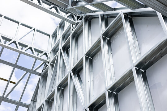 New home construction framing. Metal stud framing system with rust resistant coating in a drywall assembly. Structure of steel for building construction. Metal house frame.