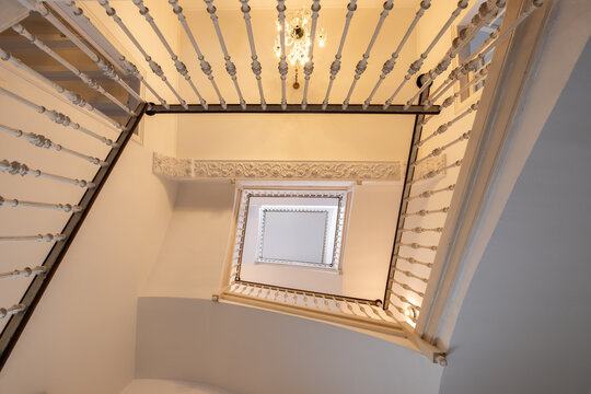 Perspectiva en contrapicado del hueco de una escalera con dise&ntilde;o geom&eacute;trico y l&iacute;neas arquitect&oacute;nicas