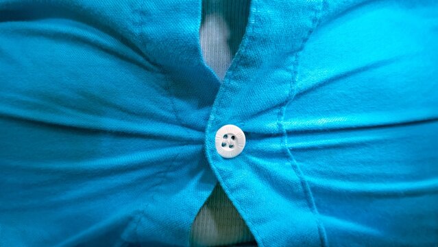 Close up of tight blue shirt button straining from overweight