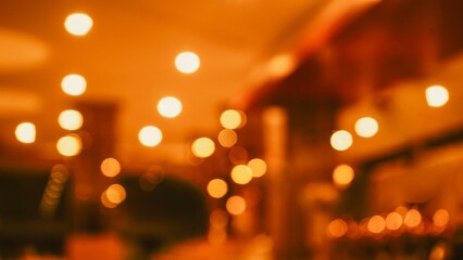 Golden orange bokeh lights blurred background for festive atmosphere © Liada