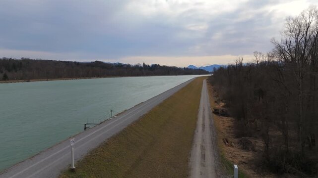 Wide angle spring landscape of Inn waterway near Rosenheim Upper Bavaria Germany. Crystal blue water with lush green shores. Bird eye view of reservoir and river current in German countryside