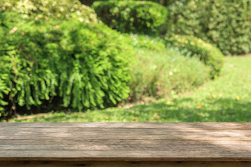 Obraz premium Empty wood table top with abstract blur park garden background
