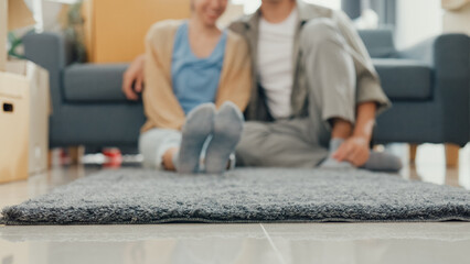 Close-up carpet. Happy Asian couple rolling out gray carpet relaxing smiling take a rest after moving stuff on living room at new house. Husband wife move house, Apartment Rent And Ownership Concept.