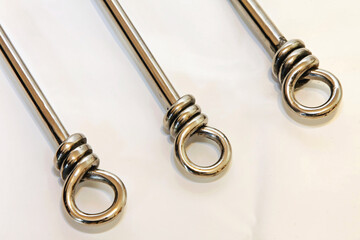 Three stainless steel knot style fork at white table