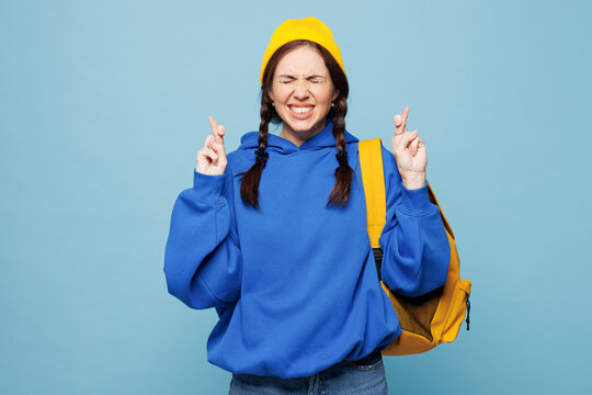 Young smart woman student she wear casual clothes yellow backpack bag hold books isolated on pastel plain light blue color background studio portrait. High school university college lifestyle concept.