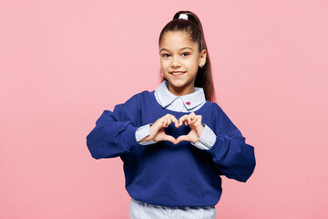 Little kid girl 8-9 years old wears blue shirt show shape heart with hands heart-shape sign...