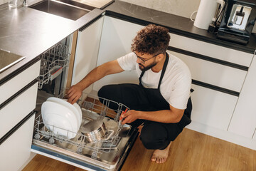 Man putting dirty dishes in the dishwasher